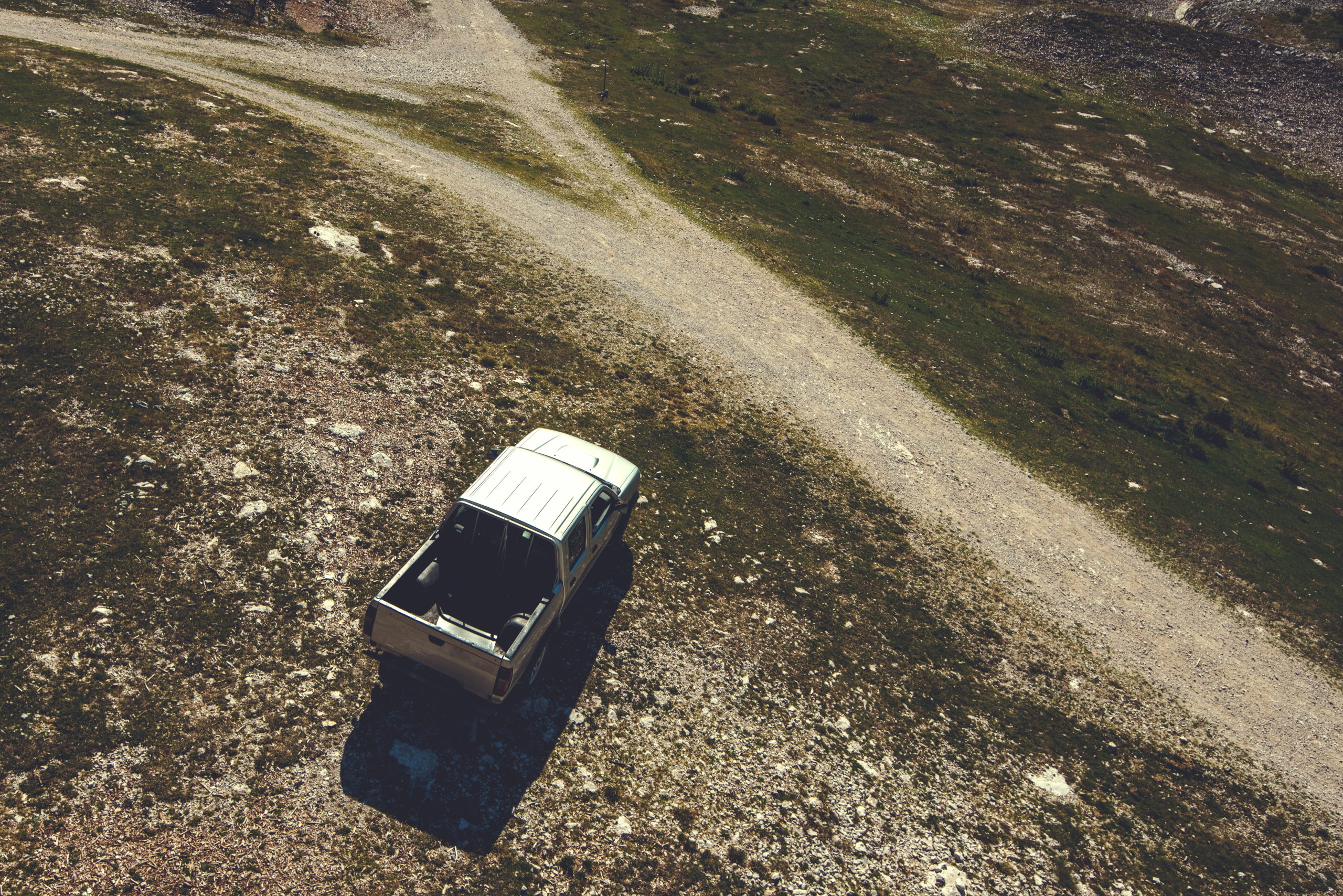 Pick up truck on mountain road, aerial view of the vehicle